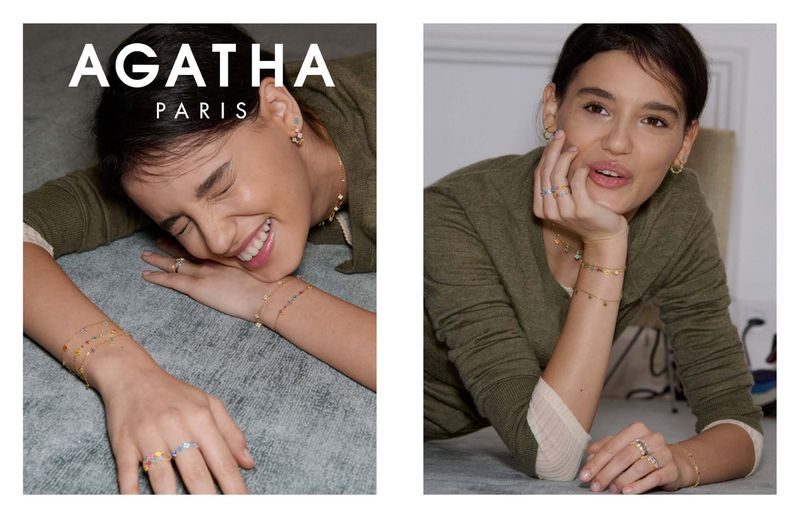 Close-up of a smiling woman wearing jewelry, including a necklace, earrings, and bracelets from Agatha Paris. Fashion shoot, beauty.