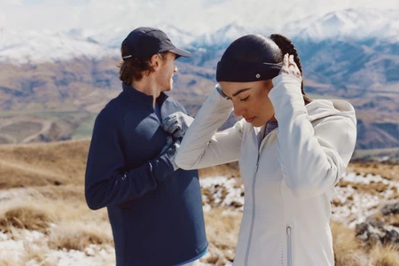 Two runners in athletic apparel standing outdoors in a snowy mountainous landscape for lululemon