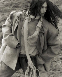 Monochrome fashion portrait of a model with long dark hair wearing an oversized tailored blazer and scarf for Vautrait.