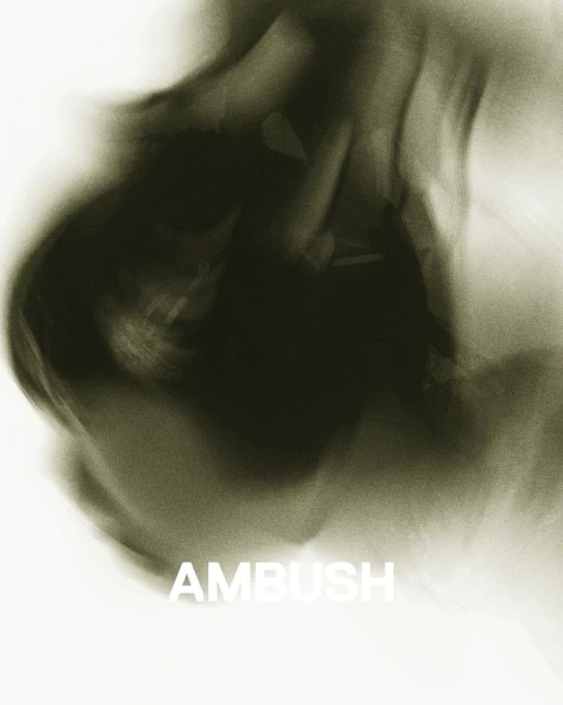Abstract motion blur of green and white creates a smoky effect.  The word AMBUSH is visible in white lettering at the bottom.