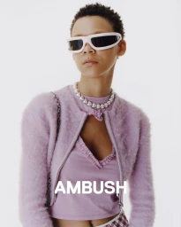 Model wearing white sunglasses and a lavender fuzzy zip cardigan against a plain white background with Ambush branding