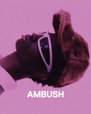 Model wearing a fuzzy fur hat and white sunglasses against a solid pink background for Ambush SS25