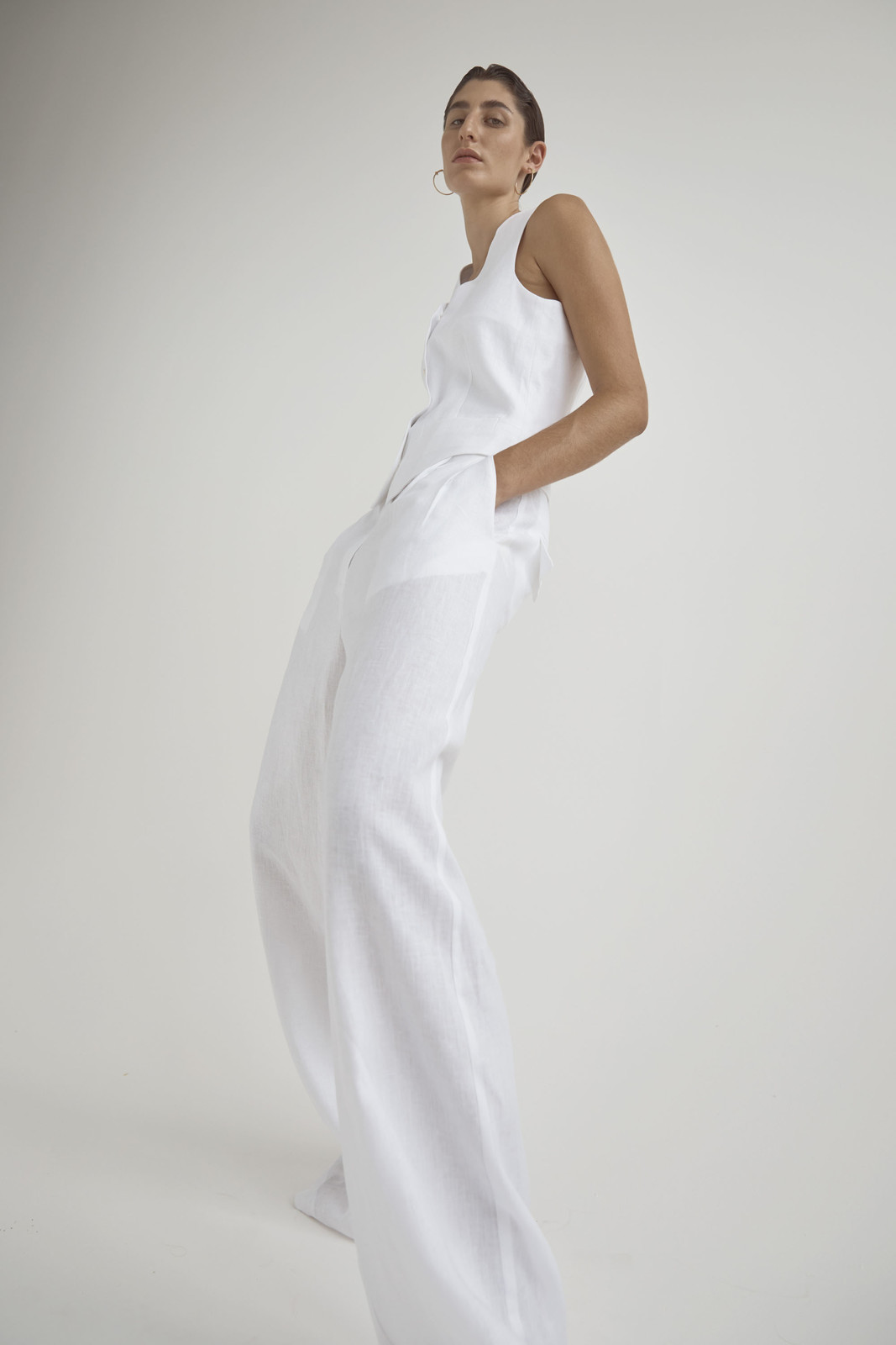 Model wearing a white sleeveless vest and trousers against a plain white background for Love Want Issue 24.