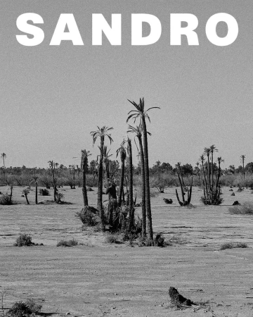 Monochrome desert landscape featuring sparse palm trees and the SANDRO logo, emphasizing nature and minimalist design, editorial in style.
