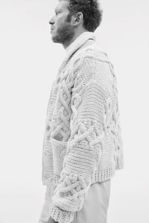Man wearing a textured cable-knit cardigan against a clean white background for Mytheresa fall winter menswear campaign