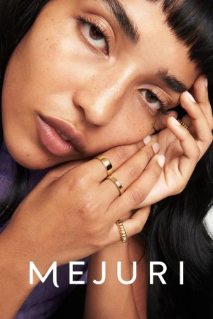 Close-up of a young adult female model with gold rings on her fingers, wearing a purple top and black hair, with the MEJURI logo.