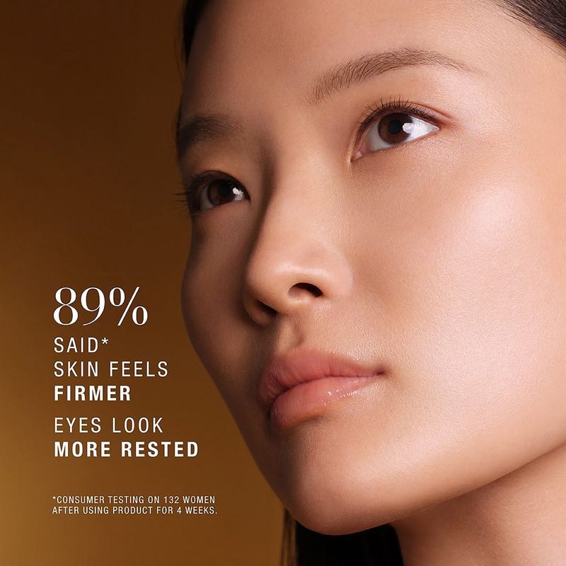 Close-up of an Asian woman's face with clear skin, softly lit against a warm brown gradient backdrop, alongside cosmetic promotional text.