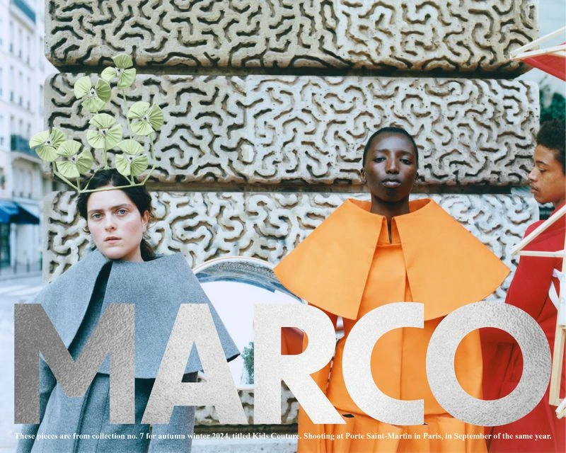 Fashion editorial shot of three women wearing modern dresses, standing against an architectural background. Bold 'MARCO' overlay.