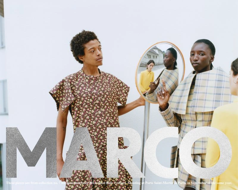 Fashion editorial shot featuring three adult female models in stylish outfits posing against a minimalist white wall backdrop.