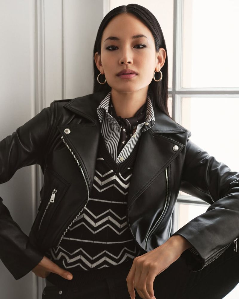 Model Hyunjoo Hwang in black leather jacket and patterned V-neck sweater posing indoors by a window for Ralph Lauren.