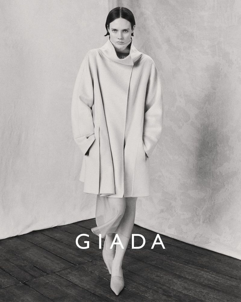 Model wearing a light-coloured coat standing against a textured backdrop for Giada Fall/Winter 2024 campaign