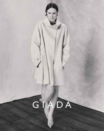 Model wearing a light-coloured coat standing against a textured backdrop for Giada Fall/Winter 2024 campaign