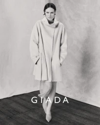 Model wearing a light-coloured coat standing against a textured backdrop for Giada Fall/Winter 2024 campaign