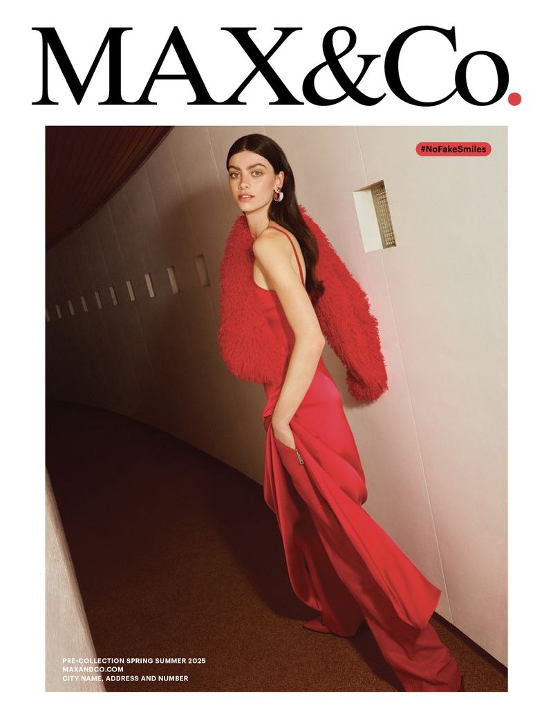 Fashion editorial shot of a stylish woman wearing a red dress and boa posing in a hallway, promoting the MAX&Co brand.
