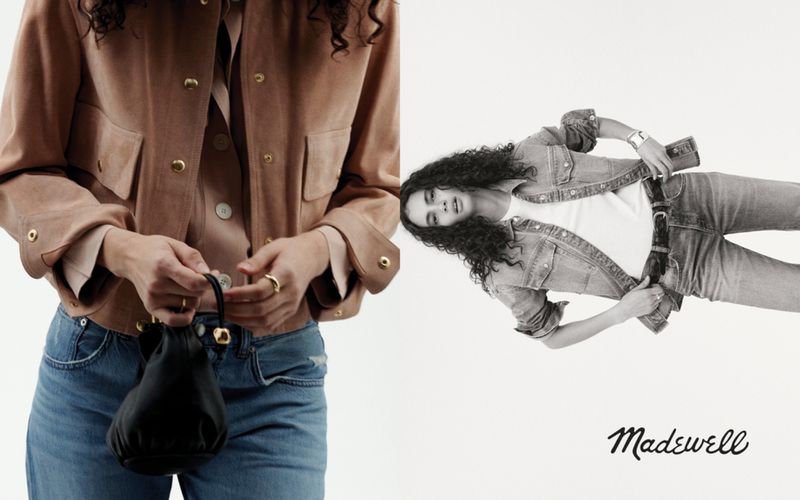 Two women pose wearing denim and a tan suede jacket with a black drawstring purse against a white background with the Madewell logo.