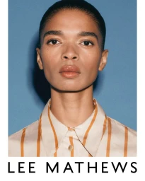 Portrait of a model wearing a striped shirt against a blue backdrop with brand text below