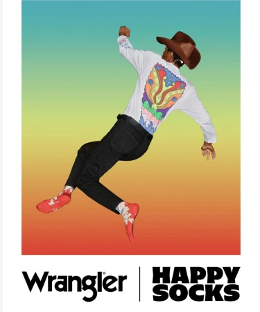 Person in a cowboy hat and long sleeve shirt jumping against a gradient background with Wrangler and Happy Socks logos at the bottom.