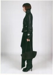 Woman wearing black leather jacket and long skirt holding a handbag against a seamless white background for Mango