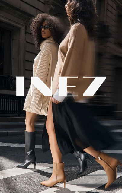 Two women in stylish autumn outfits are walking on a pedestrian crossing. One is wearing boots and a sweater dress.