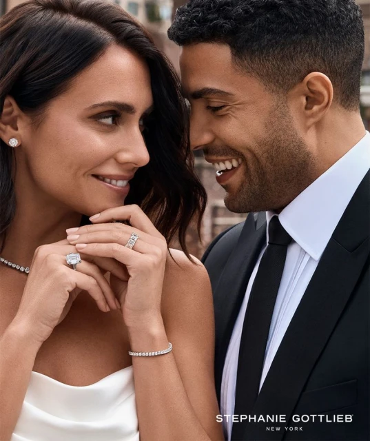 Close-up of an affectionate couple in formal wear, showcasing elegant jewelry against an urban backdrop. Jewelry advertisement.