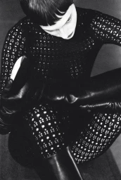Model wearing patterned black top and tights posing with tall leather boots for Aeyde campaign