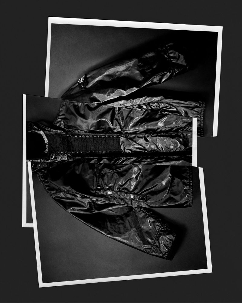 Fashionable black puffer jacket artfully displayed with white frames on a dark background, creating a modern and stylish composition.