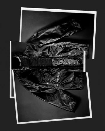 Fashionable black puffer jacket artfully displayed with white frames on a dark background, creating a modern and stylish composition.