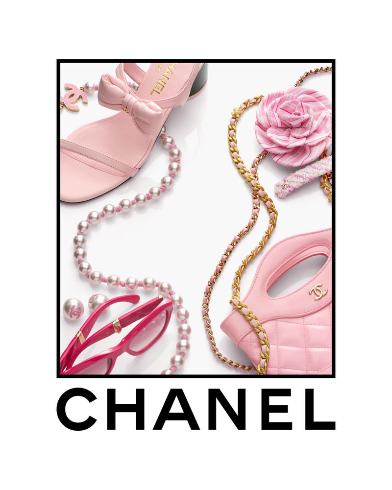 Still life of pink Chanel sandal, handbag, sunglasses, necklace, and flower with gold chain on a white background, studio lighting.