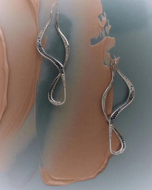 Elegant silver earrings with black and white accents showcased on a softly colored background, ideal for jewelry promotion and fashion.
