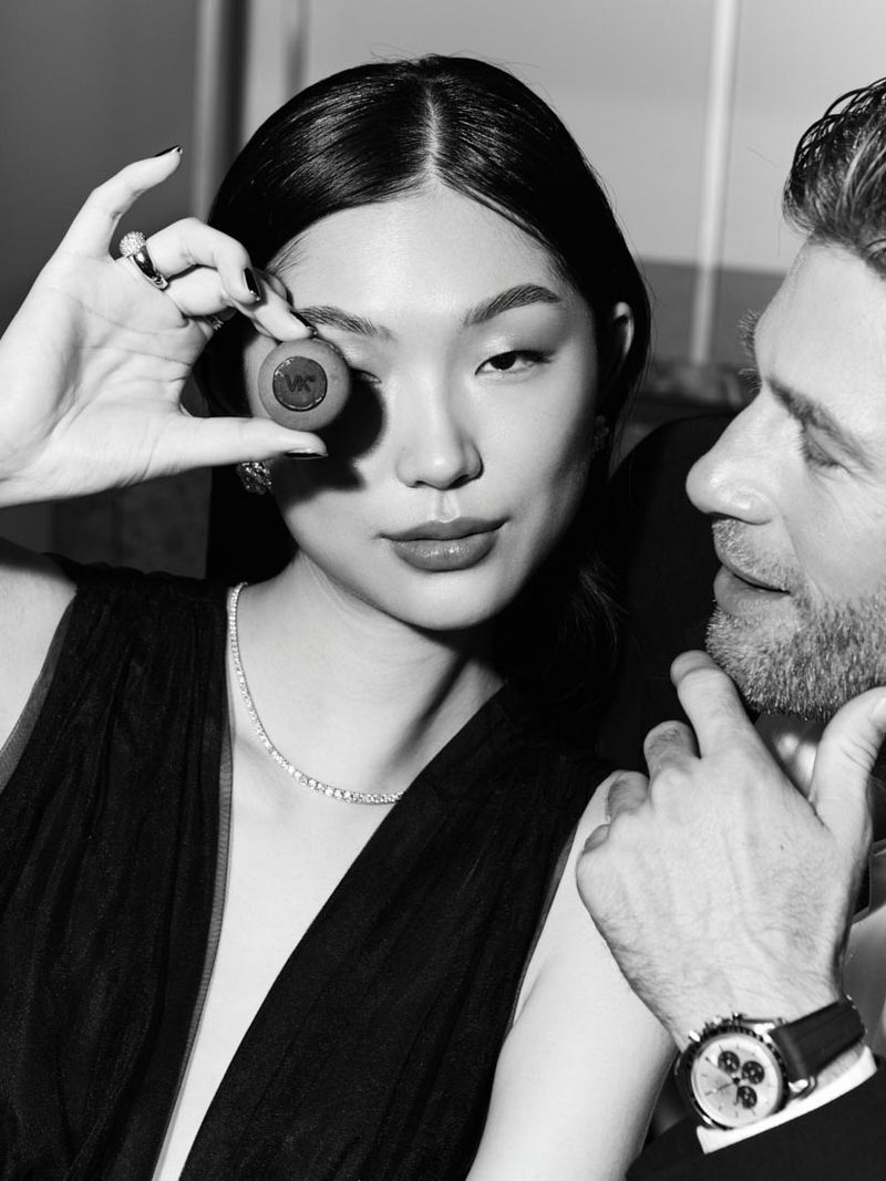 Elegant portrait in black and white of an Asian woman with brown eye contact lens and a man with a watch, wearing formal attire.