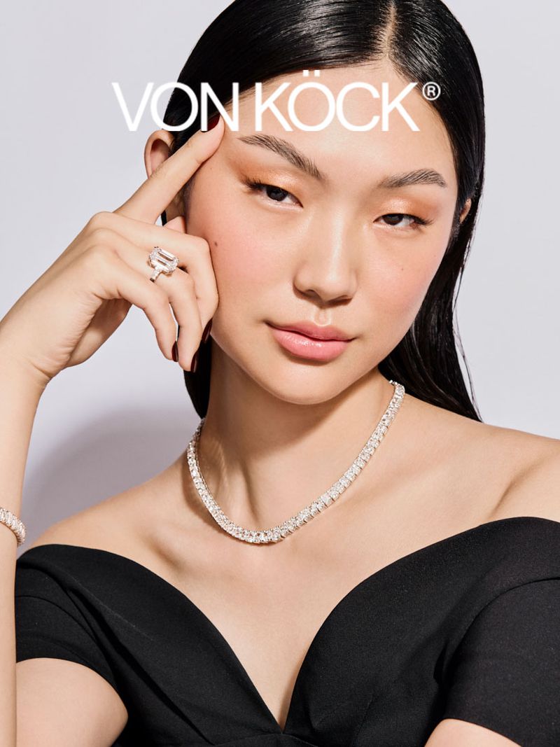 Model wearing diamond jewelry including an emerald cut ring and tennis necklace against a clean white backdrop for VON KOCK