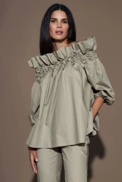 Model Raica Oliveira wearing an off-the-shoulder smocked sage top and matching trousers by photographer Olga Rubio Dalmau.