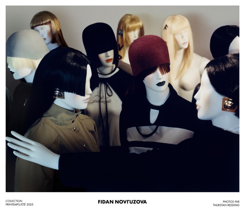 Fashion photography of mannequins wearing hats and dresses with dark lipstick. The photo has retro vintage appeal with muted colors.