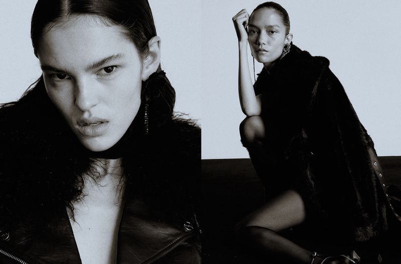 Monochrome fashion portrait of a woman in a fur coat and leather jacket, posing in a studio with dark hair and dangling earrings.