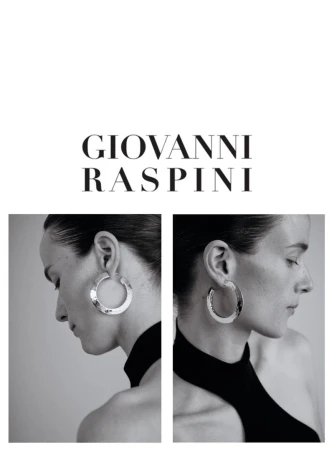 Black and white studio shot of a woman with elegant silver hoop earrings, sleek hairstyle, and black turtleneck top.