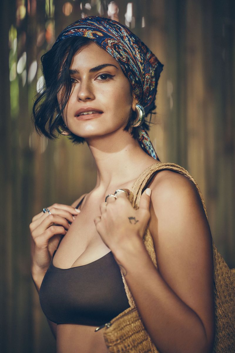 Model Hannah Kleit wearing a headscarf and swimsuit holding a woven bag for Simons Canada Swim '24 campaign photographed by Richard Bernardin.