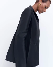 Model wearing a black blazer and gold earring against a white background for Net-A-Porter Khaite PS25