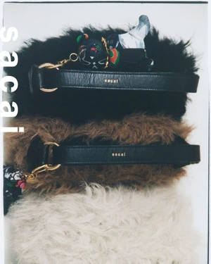 Three stacked fluffy shearling handbags in black, brown, and white with leather straps, shot from above against a plain background
