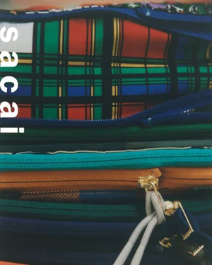 Close-up of stacked colourful plaid bags with visible zippers for Sacai Holiday Collection 2024