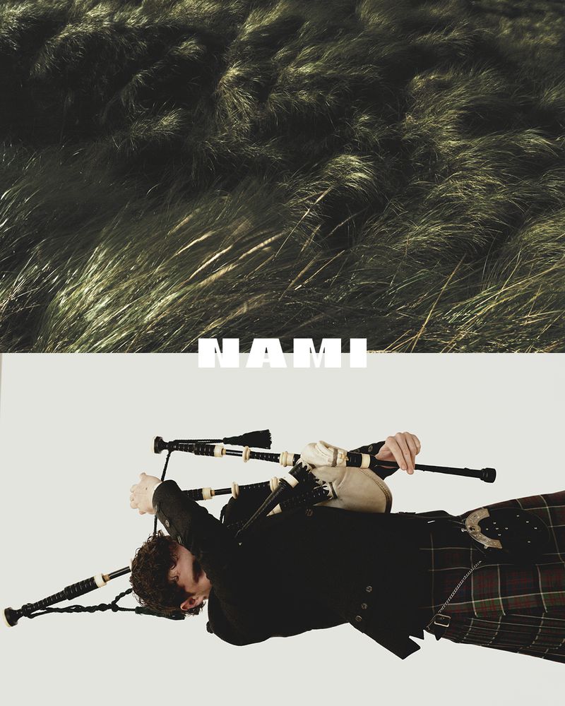 A person playing bagpipes in the bottom half of the frame, with a field of grassy plants in the top half of the frame.