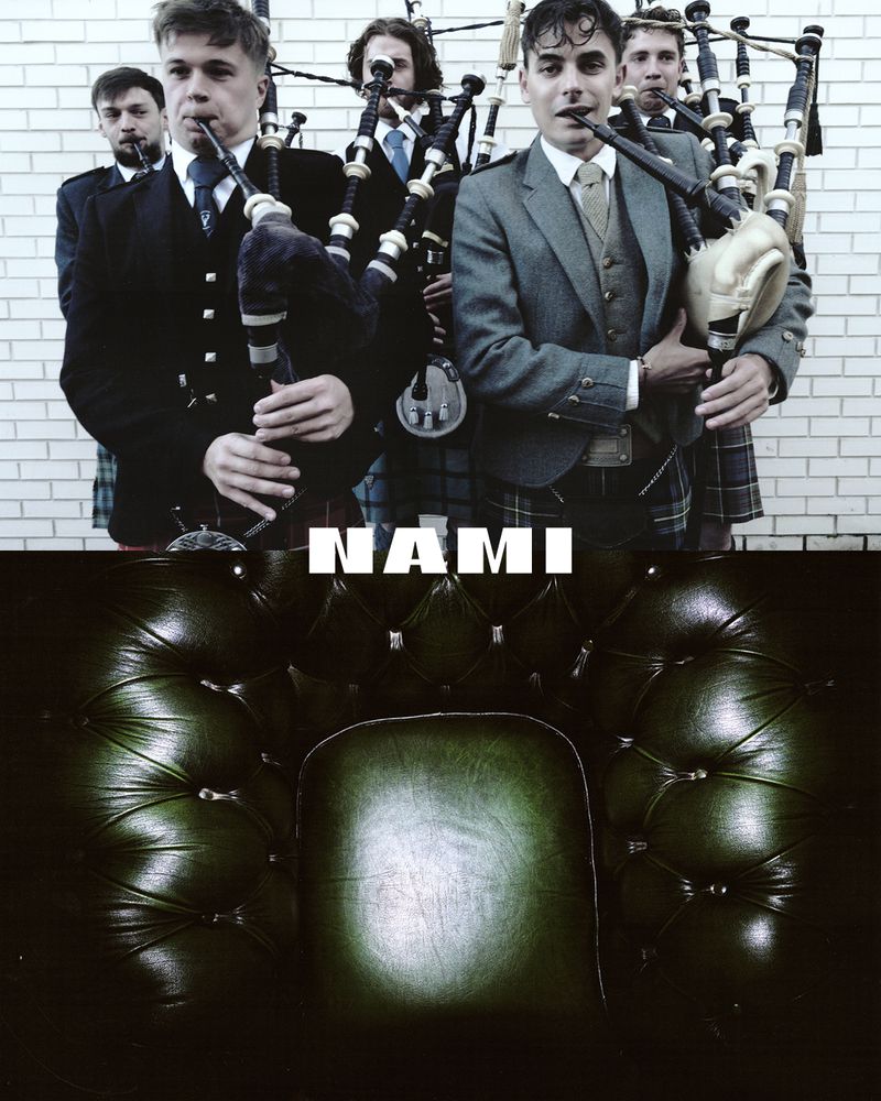 Group of men in suits and kilts playing bagpipes in front of a brick wall, with a leather armchair in the foreground.
