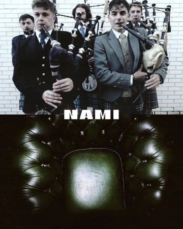 Group of men in suits and kilts playing bagpipes in front of a brick wall, with a leather armchair in the foreground.