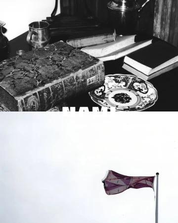 Still life photograph features an old book, metal mug, decorative plate, and UK flag against a cloudy sky, rendered in grayscale.