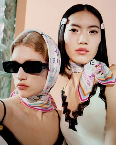 Two female models wearing patterned scarves and luxury accessories for Louis Vuitton x Murakami campaign