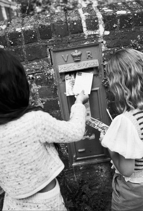 Two children posting letters in a traditional postbox for Reiss Kids Fall 2024 campaign, photographed by Alex Moro.