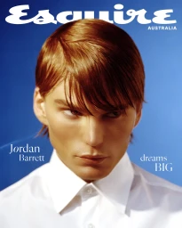 Close-up portrait of model Jordan Barrett wearing a white buttoned shirt against a bright blue background for Esquire Australia