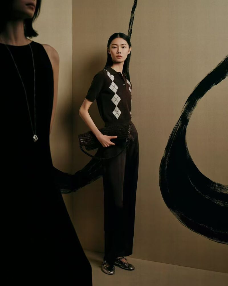 Two Asian women in a studio setting, showcasing fashion attire with one woman in a black dress and another in a patterned sweater.
