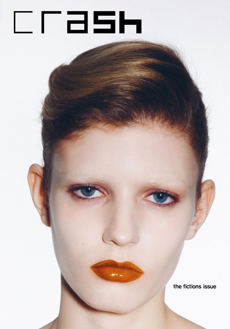 Close-up portrait of a young adult female model on a fashion magazine cover with retro-styled, short hair and striking gold lipstick.