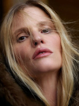 Close-up portrait of a blonde woman with loose hair across her face, captured by Mario Sorrenti for Vogue France.