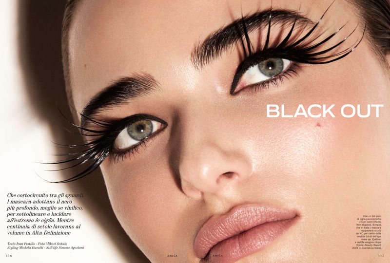 Close-up beauty shot of a woman's face with dramatic false eyelashes and defined eyebrows, showcasing makeup and facial features.